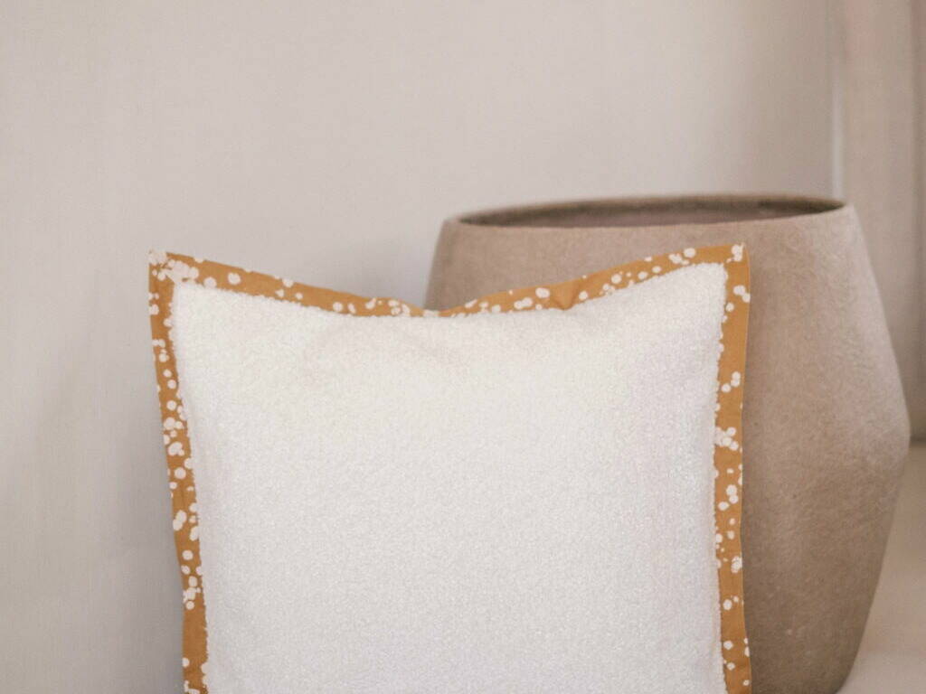 Cushion cover with a batik trim and white boucle velvet